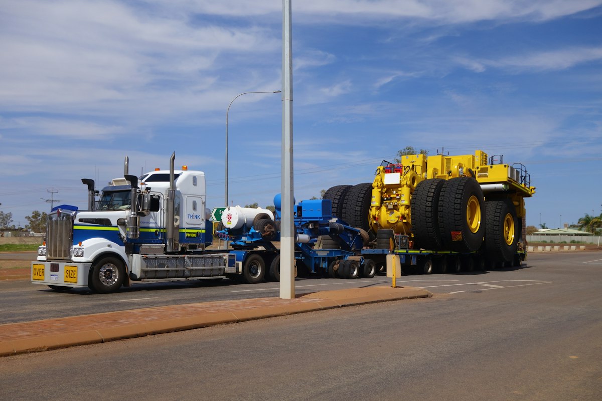 Heavy haul truck transporting an oversized mining vehicle on a multi-axle trailer