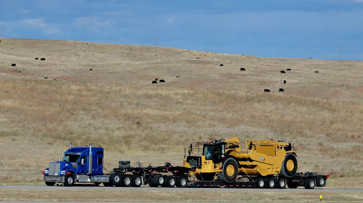 Semi truck hauling a wheel loader on a lowboy trailer